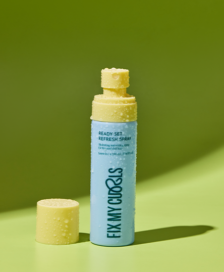 Bottle of 'Fix My Curls' Ready, Set, Refresh Spray on a green background